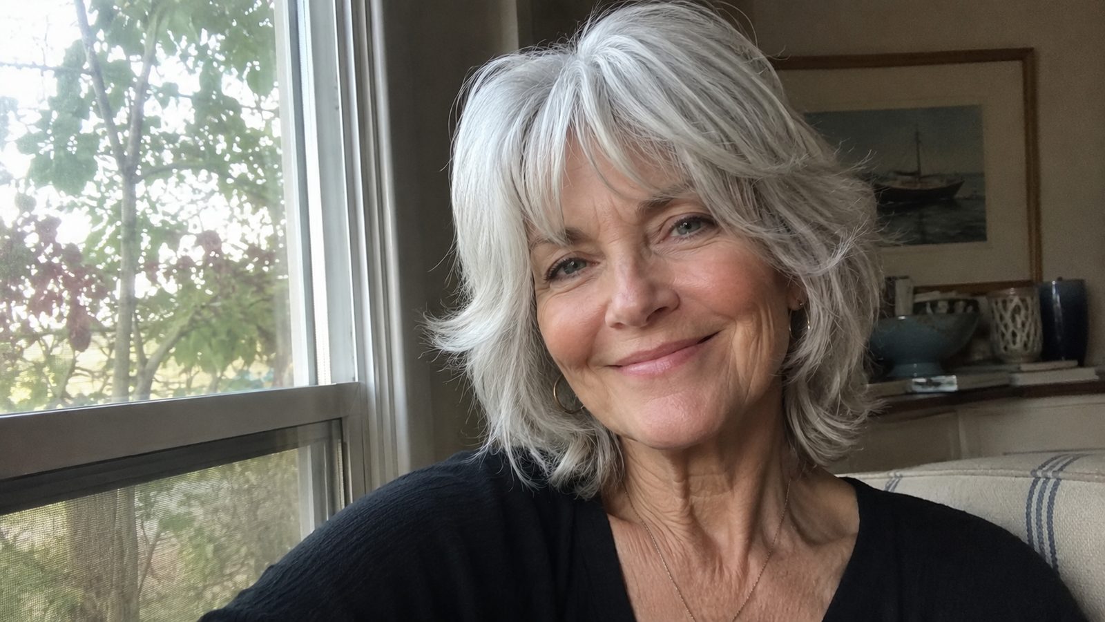 An elegant woman over 60 with a soft feathered silver shag