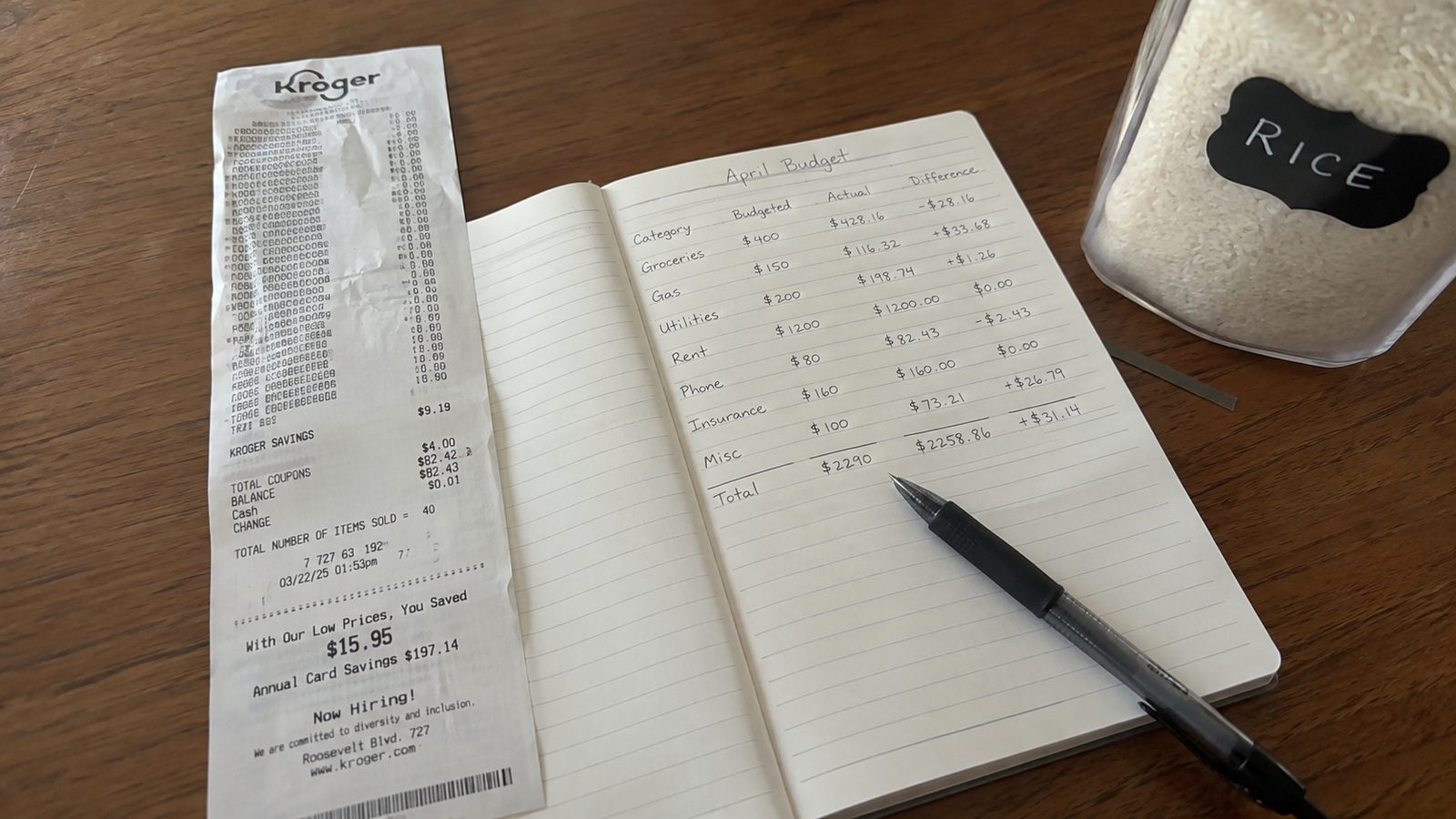 A grocery receipt beside a household notebook and pen